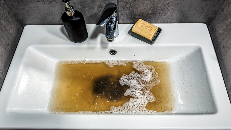 A clogged sink in a bathroom