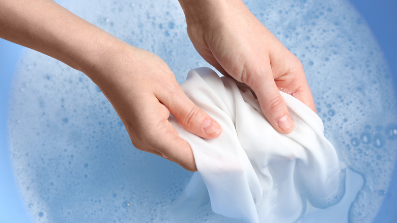 person washing cloth by hand