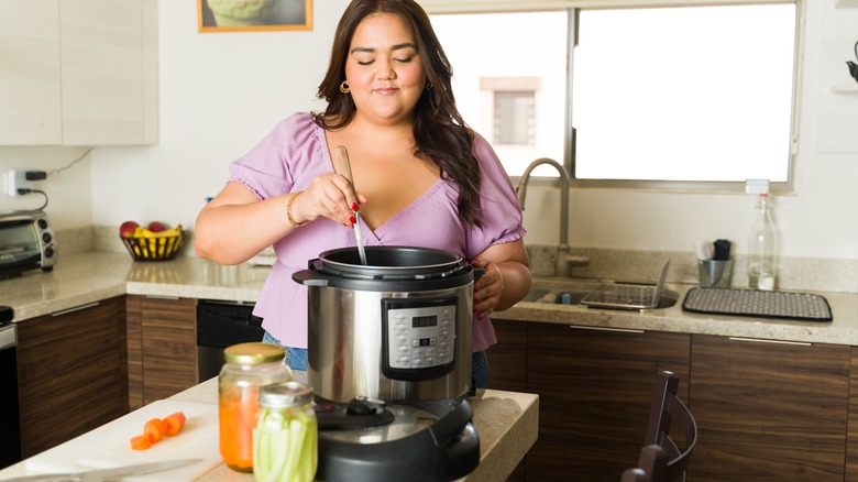 woman using slow cooker