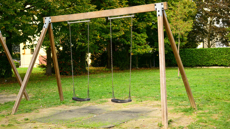 wooden swing set in grass