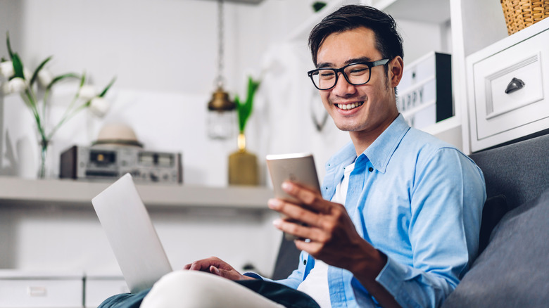 man with laptop and phone