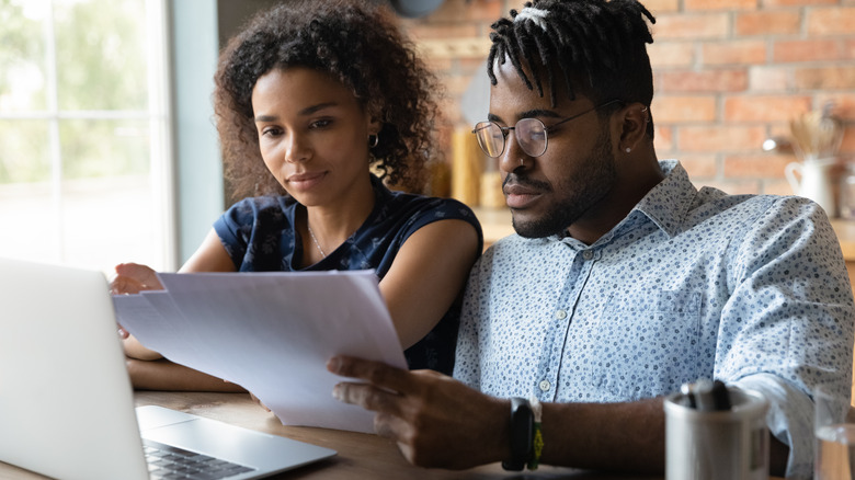 couple researching houses on laptop