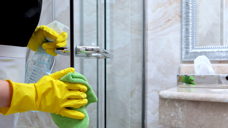 person cleaning shower door