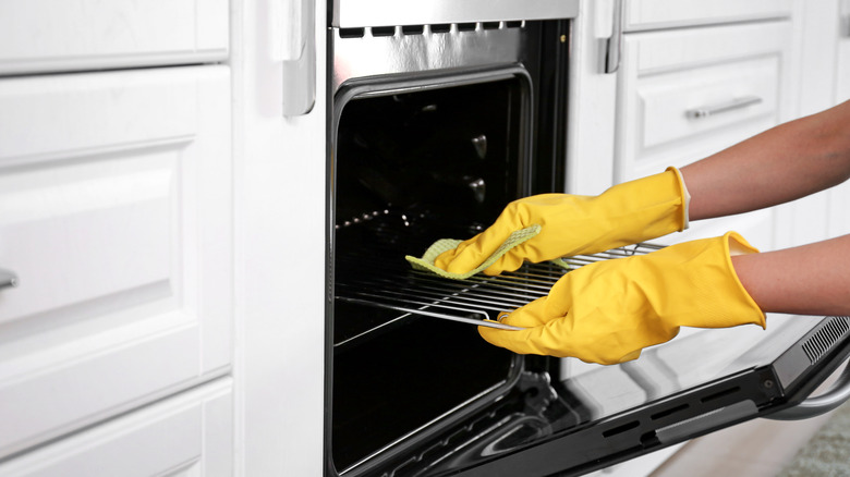 Person scrubbing oven clean