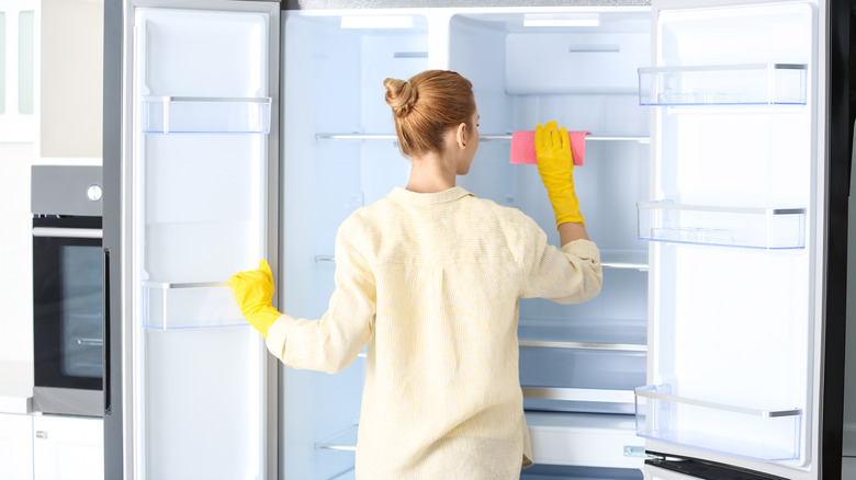 Person cleaning empty fridge