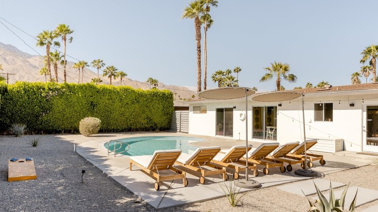 white lawn chairs and pool