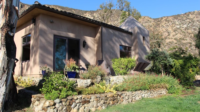 tan stucco house against mountains 