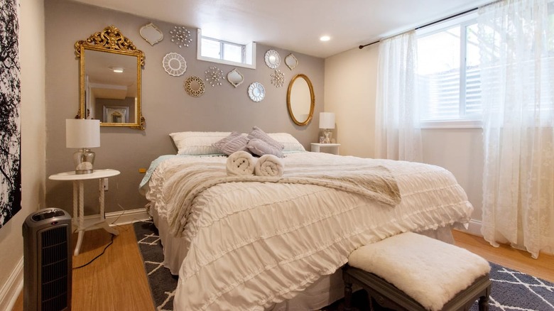 white bed with mirror gallery wall