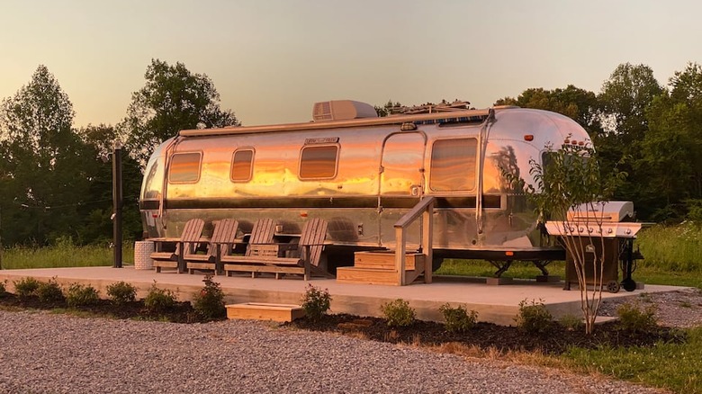 Airstream with deck reflecting sunset 