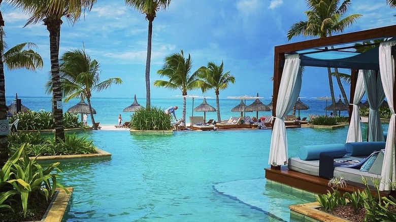 blue pool and cabana in front of ocean