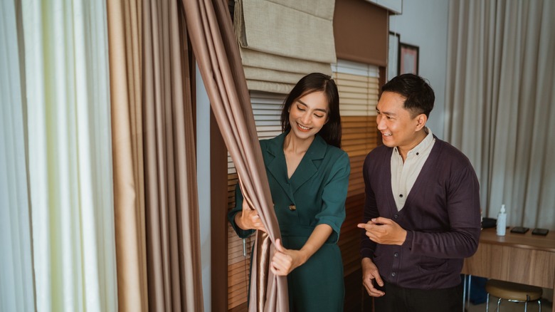 A woman and man shop for curtains