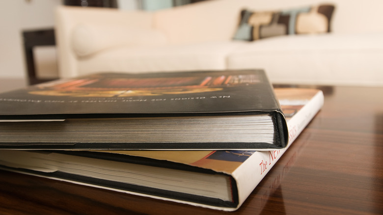 Two coffee table books with a white sofa in the background