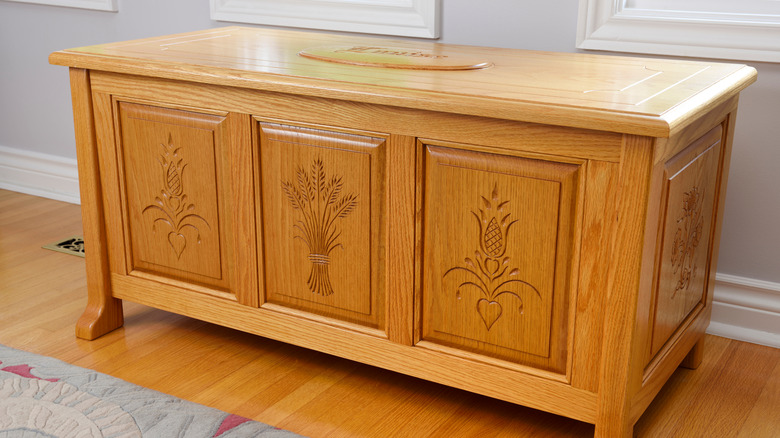 Honey-toned hope chest againts a soft gray wall