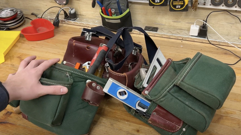 green and red leather luxury tool bag belt on wood table