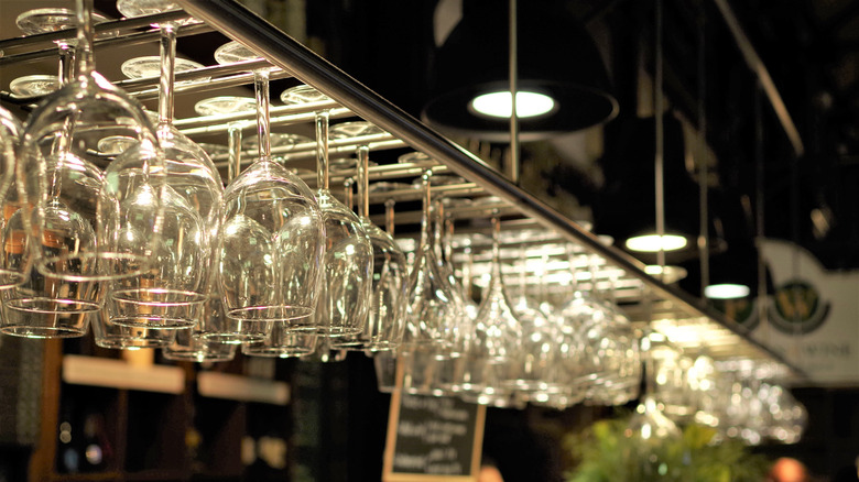 cocktail glasses hanging in bar