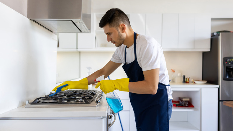 man cleaning stove