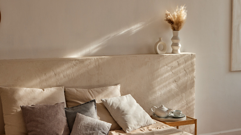 Bedroom with stone headboard and decorative items.