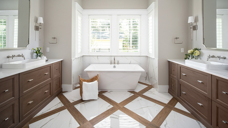 Bathroom with brown cabinets, brown floor detailing, and light walls