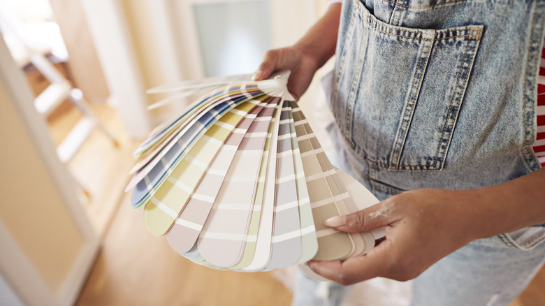 Woman looking through paint color swatches