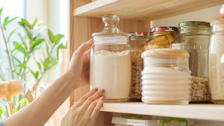 hands putting jar on shelf