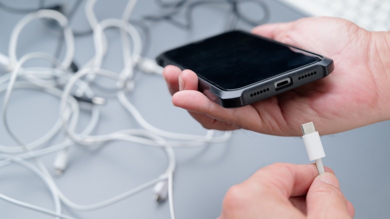 person plugging in phone with cables