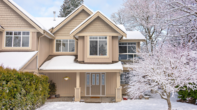 Snow-covered house with snow in front yard