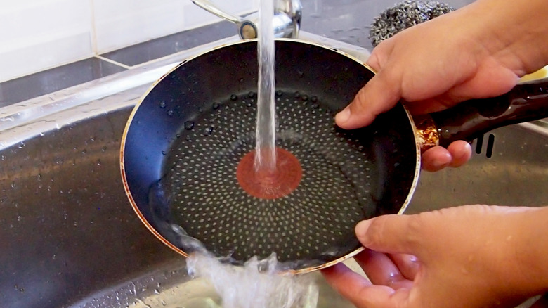 Hands washing a frying pan