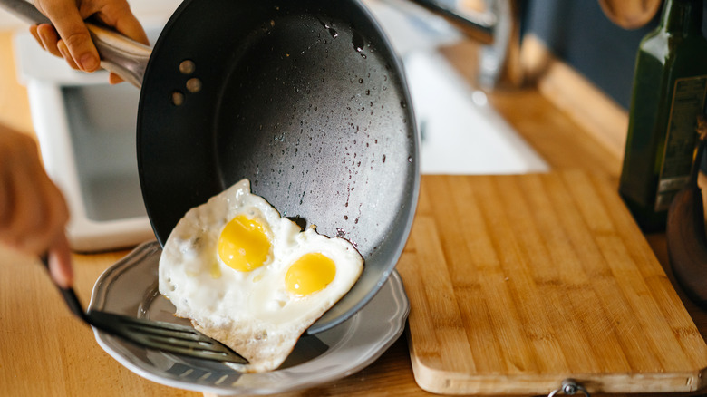 Person preparing eggs in pan