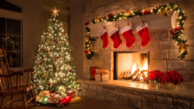 Living room and fireplace decorated for the holidays with a traditional Christmas color palette