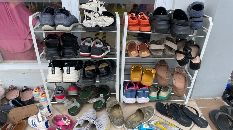 Messy shoe rack overflowing with shoes