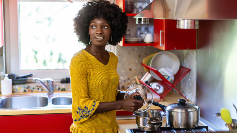 Woman standing in a kitchen with red cabinets.