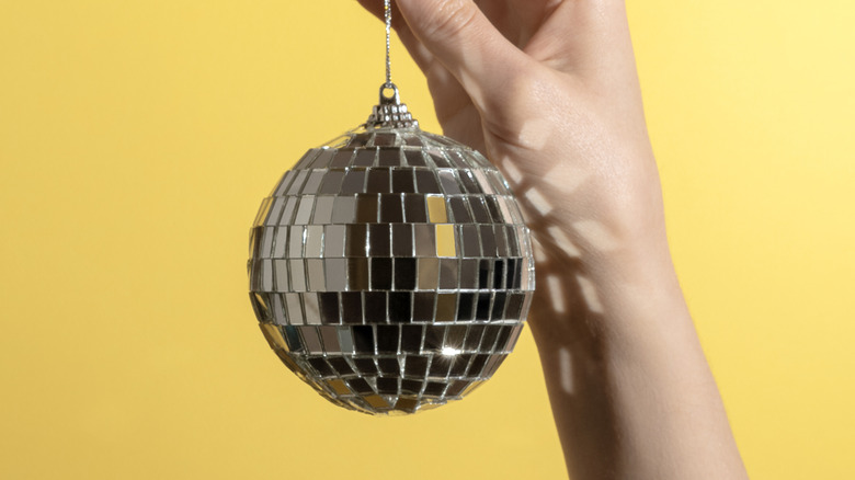 Someone holding a small disco ball ornament