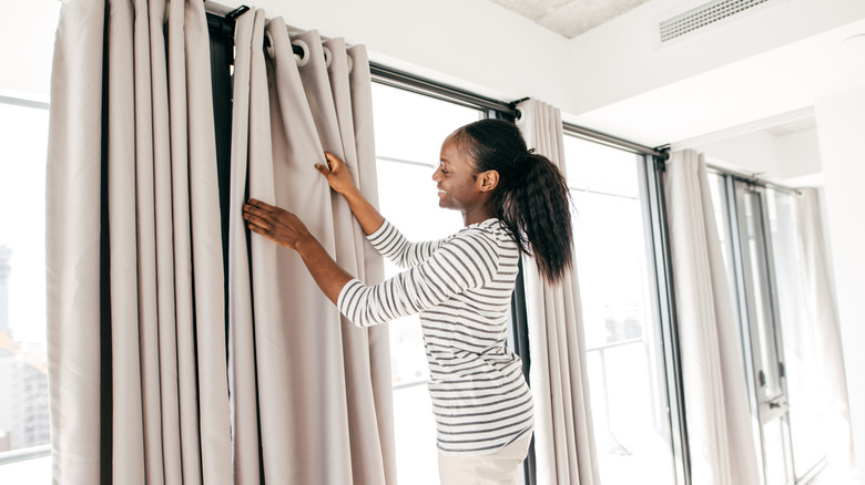 Woman putting up curtains