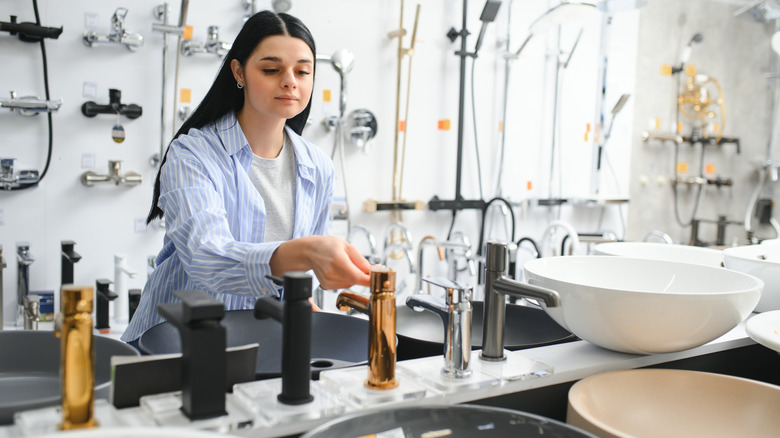 Woman looking a different faucet colors