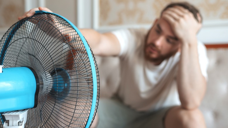 Man cooling off with fan