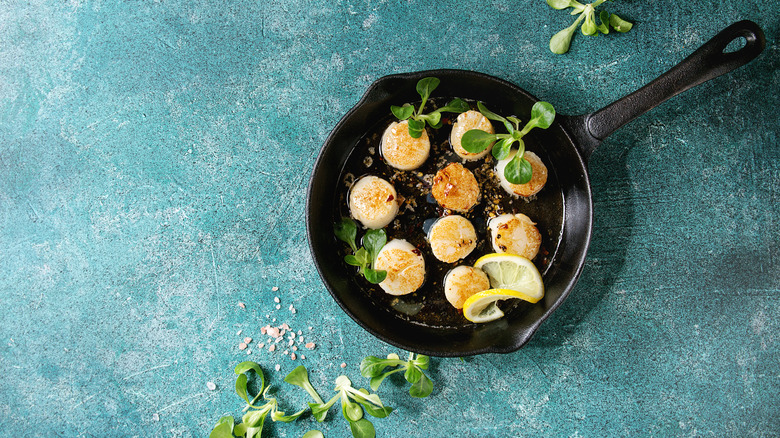 Scallops cooking in a cast-iron skillet