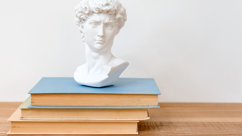 White male bust on top of books