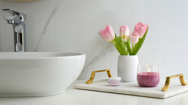 flowers and candle next to bathroom sink