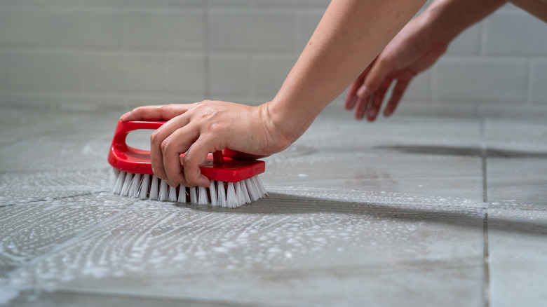 Person scrubbing bathroom floor