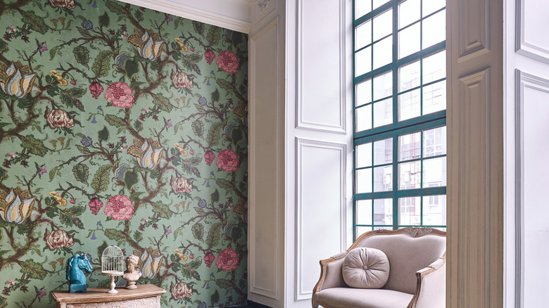 Green floral wallpaper under picture rail in high-ceilinged room