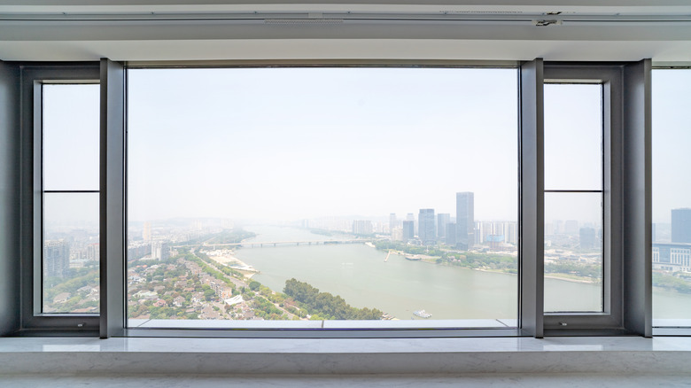 A large window over-looking a city situated on a river