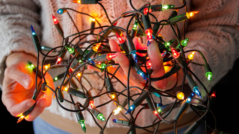 Person holding colorful Christmas lights