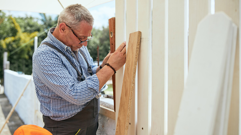 Man building a white fence