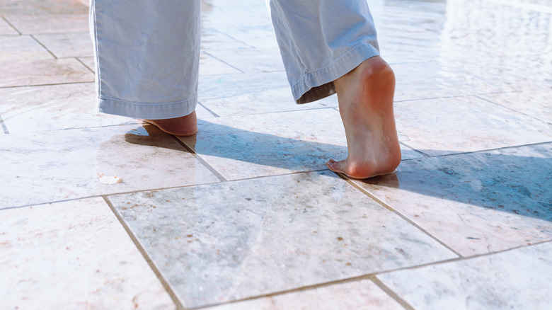 Feet walking on wet tile