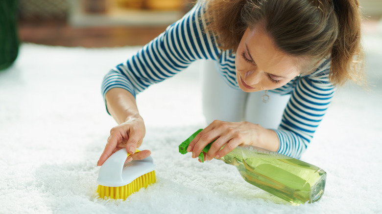 woman cleaning white carpet