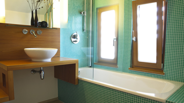 Bathroom with green tile and brown wood