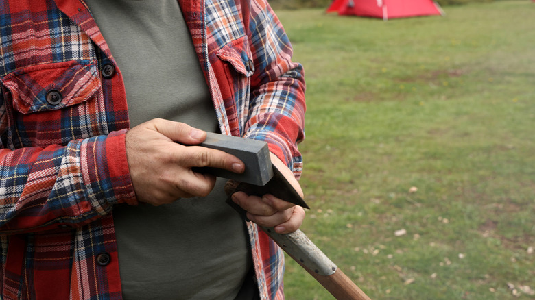 Person sharpening an axe