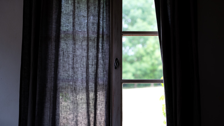 Sunny window through black curtains