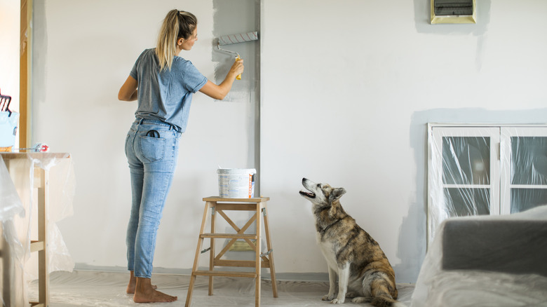 Woman painting wall with roller