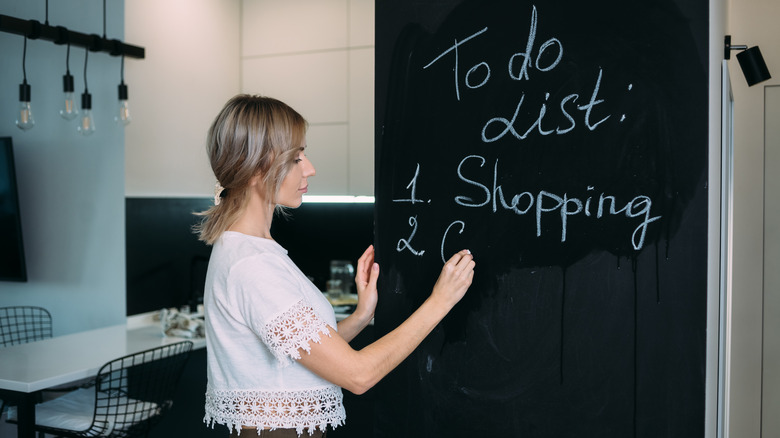 woman writing list on board